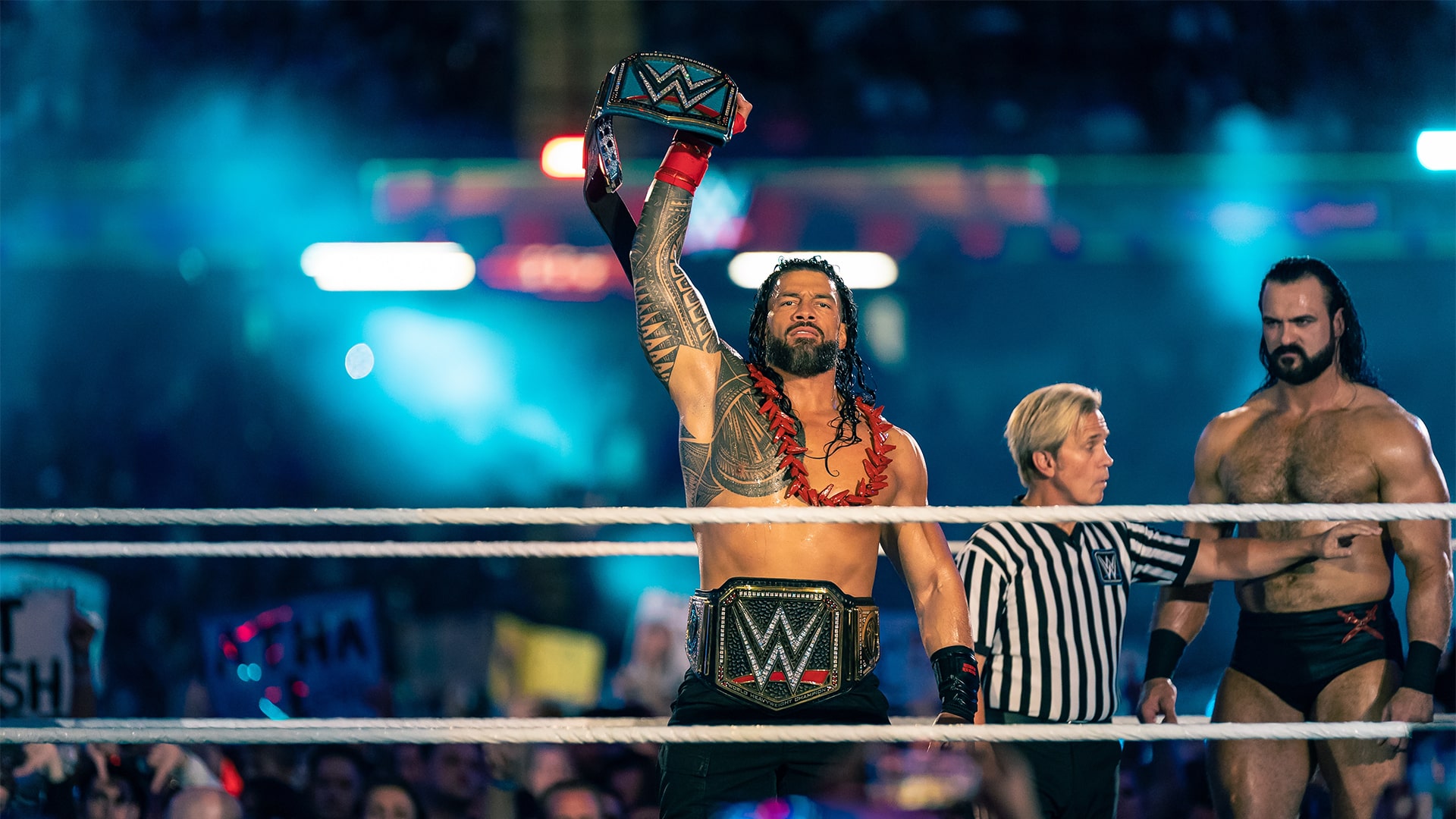 Roman Reigns holding a belt above his head