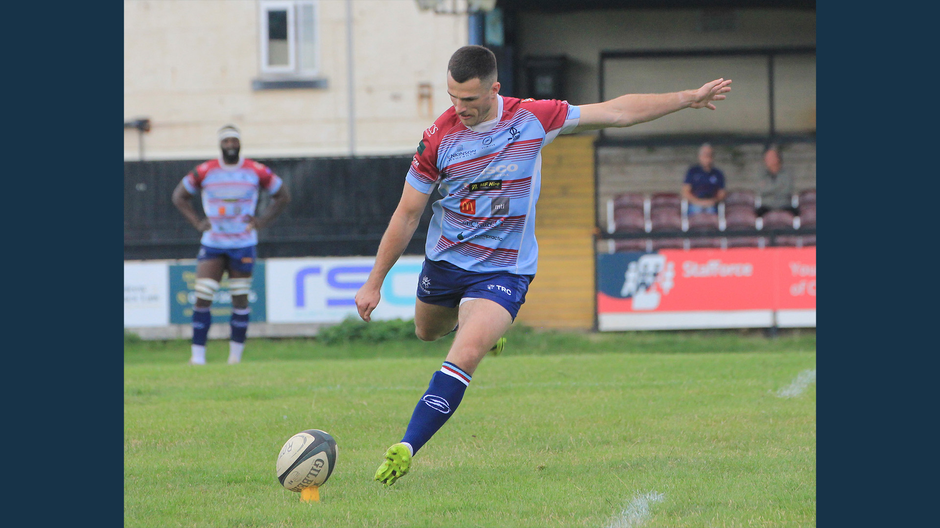 Russell Bennett kicks a rugby ball off a tee