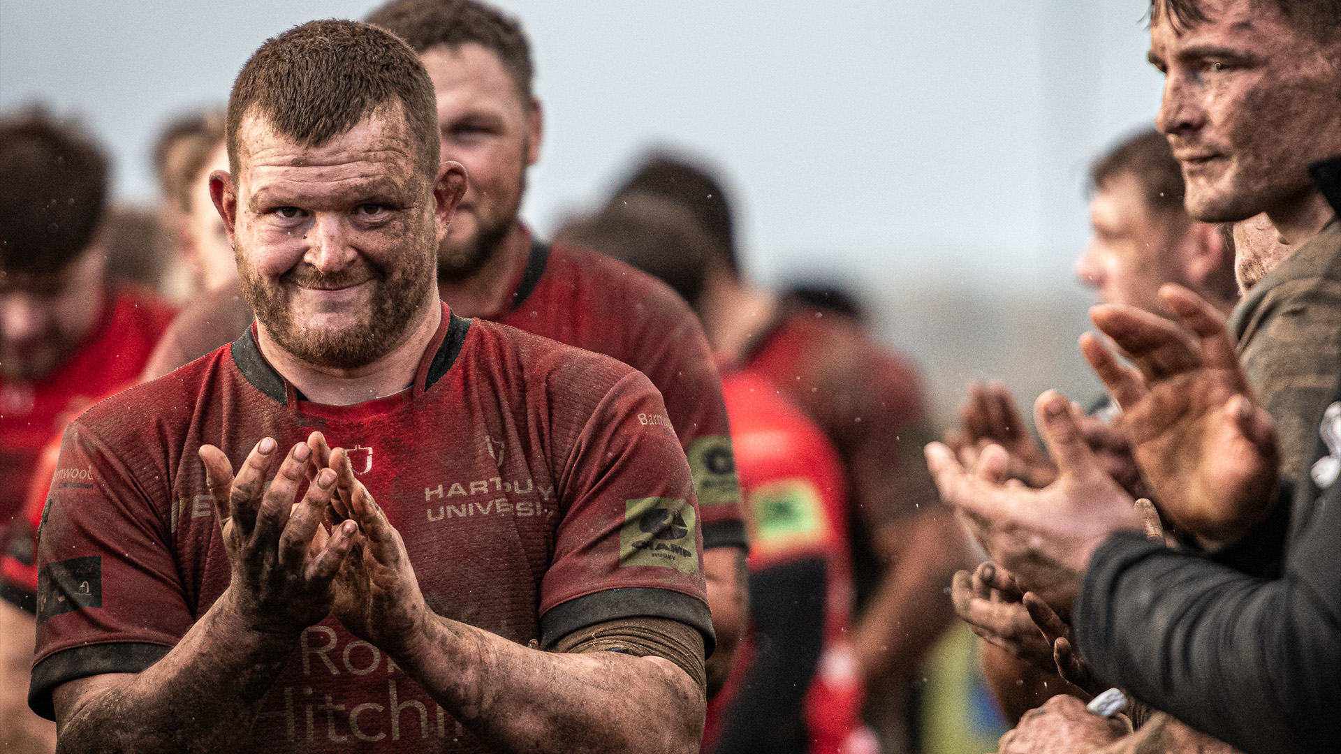 Will Crane claps while covered in mud