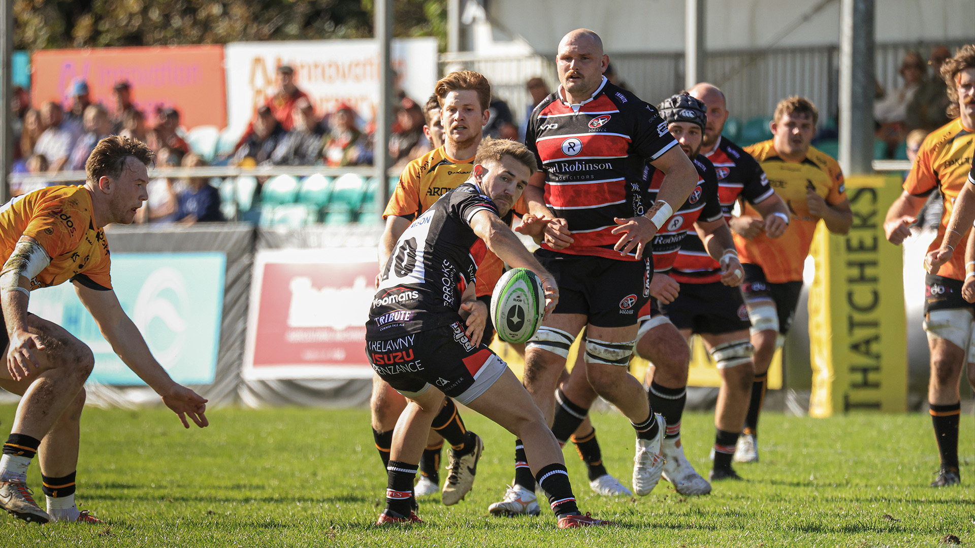 Cornish Pirates player makes a pass out the back of his hand against Chinnor