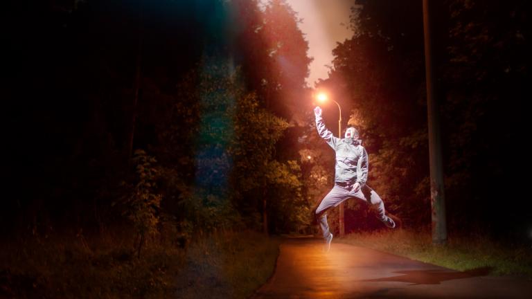 A young man floats upwards towards a light
