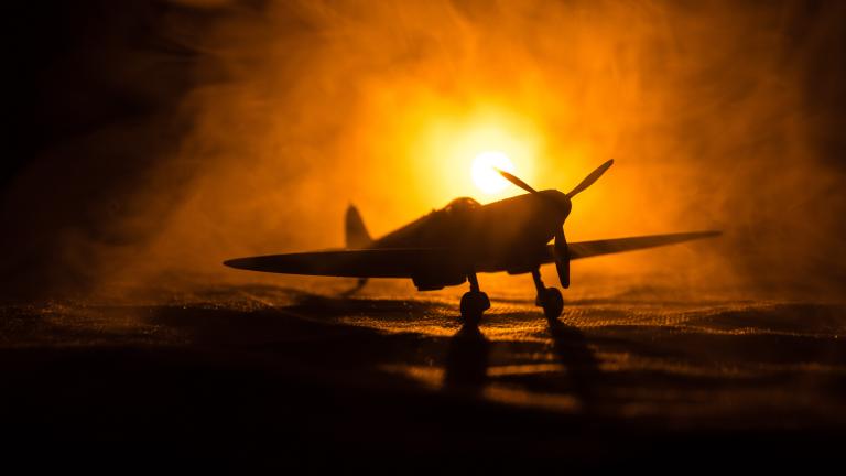 A WW2 plane in front of a misty spotlight