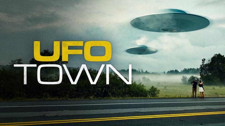 UFO TOWN - A couple stand on the side of the road watching flying saucers