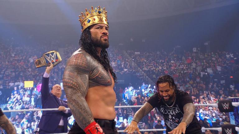 Roman Reigns stands in the ring with a crown on his head