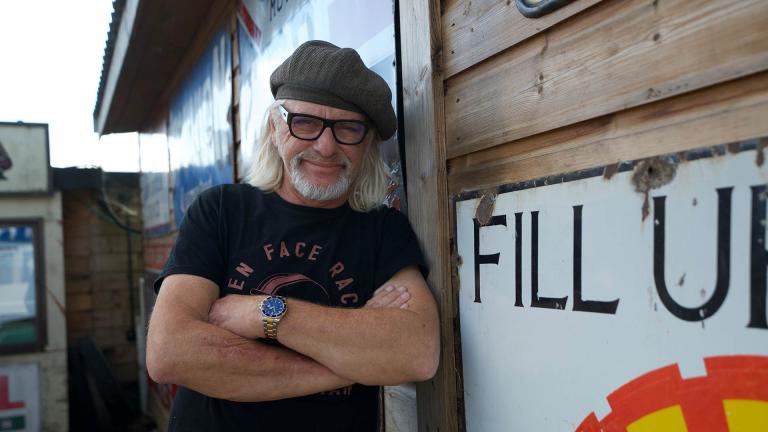 Henry Cole leaning against a shed with his arms folded