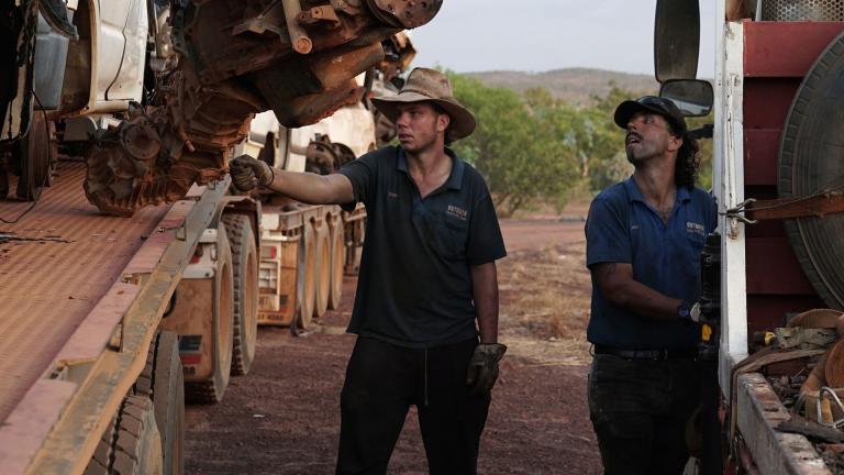 Two Outback Wreckers cast members inspect a rusted car