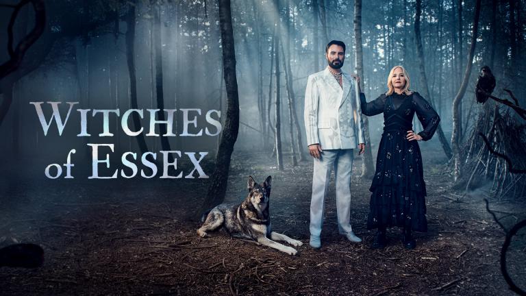 Rylan Clark and Professor Alice Roberts stand in a misty forest beside a dog, with a raven perched nearby. Text reads “Witches of Essex.”